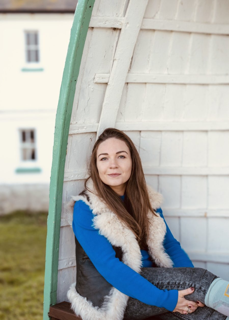 Georgie sitting relaxed inside an upturned boat shelter